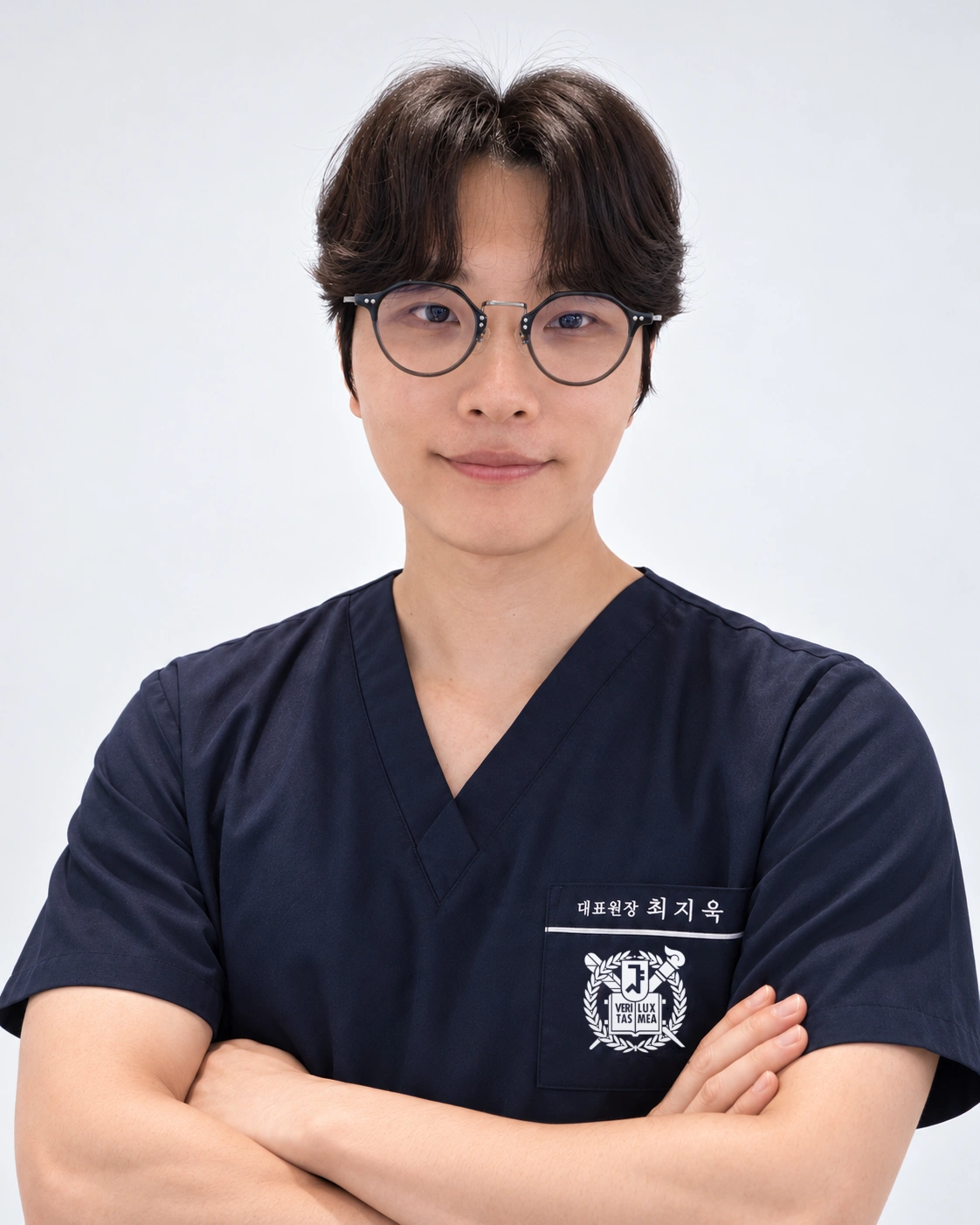 안경과 남색 진료복을 착용한 최지욱 대표원장