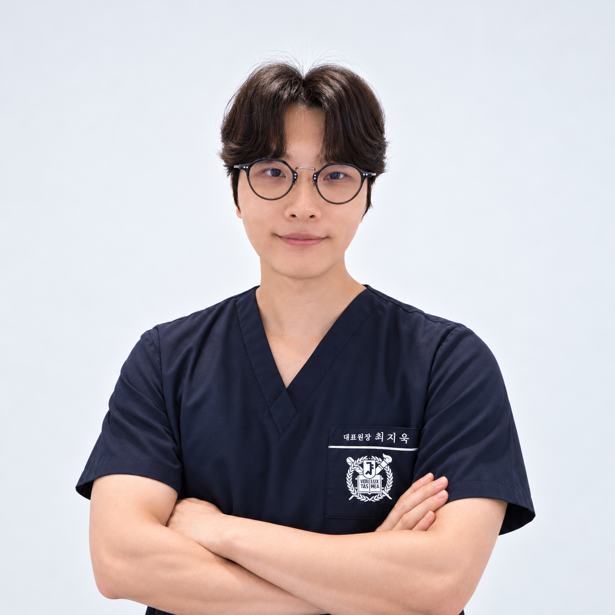 안경과 남색 진료복을 착용한 최지욱 대표원장